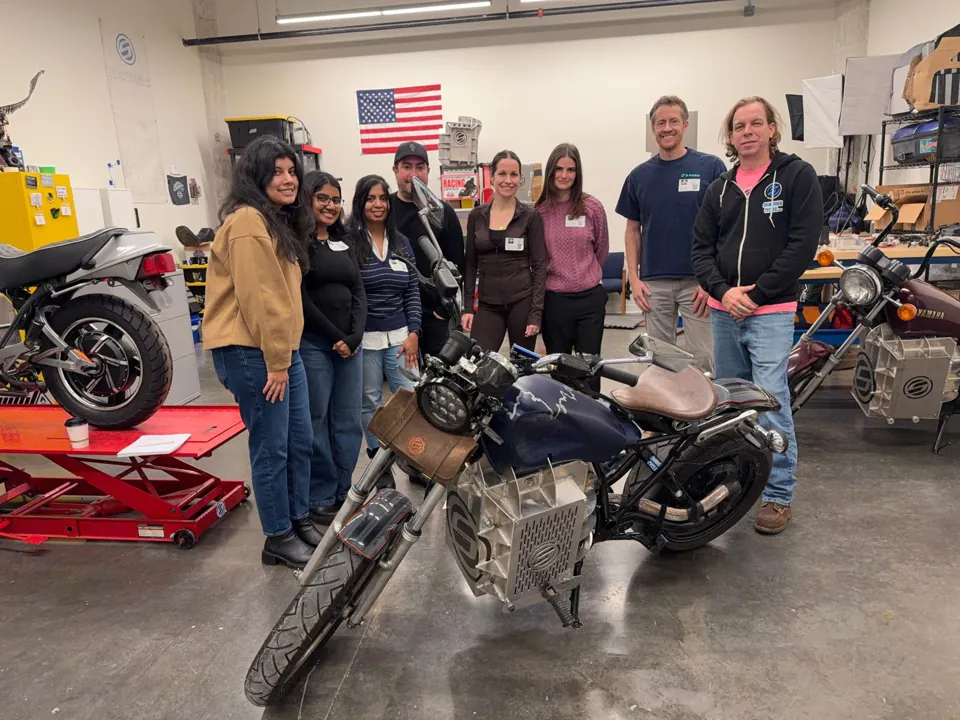 Estudiantes del College for Creative Studies con una motocicleta Shandoka en el taller