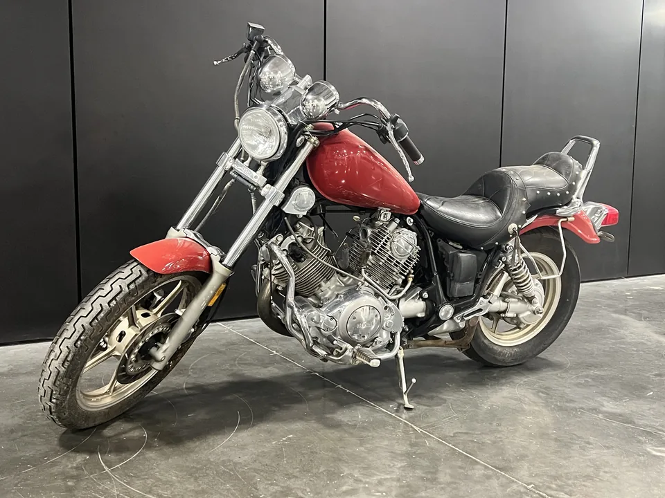 Big Red, a red Yamaha Virago 1100 cruiser, three-quarter front on the shop floor, chrome and factory paint intact.