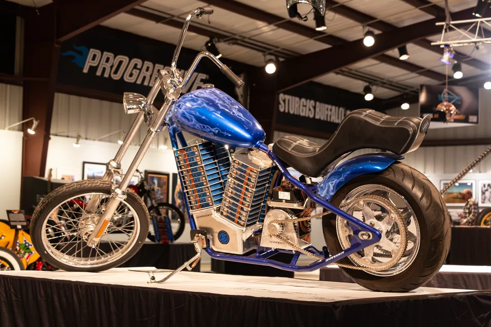 El chopper eléctrico Shandoka en el Buffalo Chip de Sturgis: chasis azul y baterías apiladas donde iría el motor V-twin.