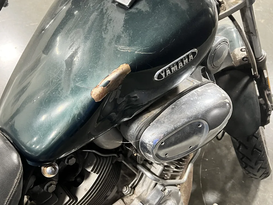 The Green Machine's tank with its Yamaha badge, the paint marked but the metal sound.